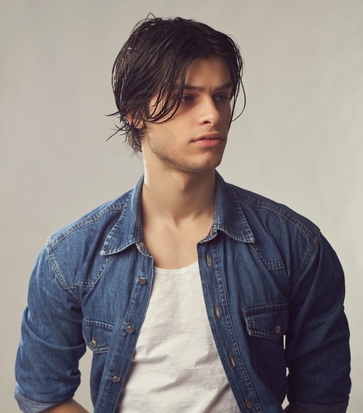 Portrait of an handsome young man in a denim shirt on a white background